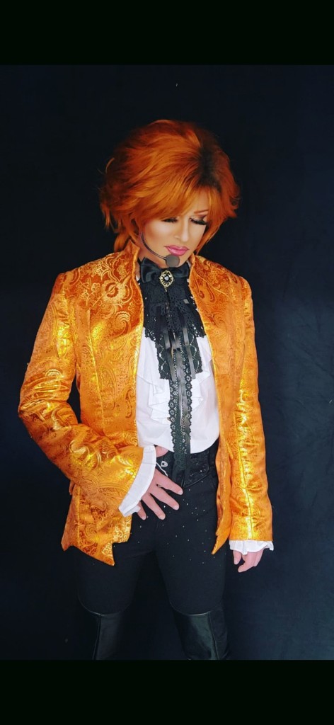 Artiste aux cheveux orangés, veste brodée or et jabot de dentelle